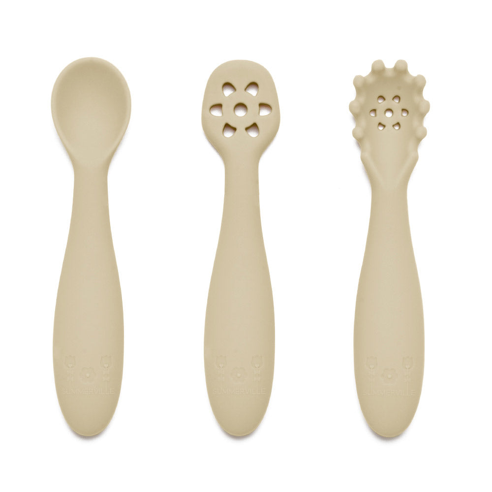 Nybegynnerskjeer i silikon i beige med glatt design og unike utskjæringer på håndtakene, sett med tre deler