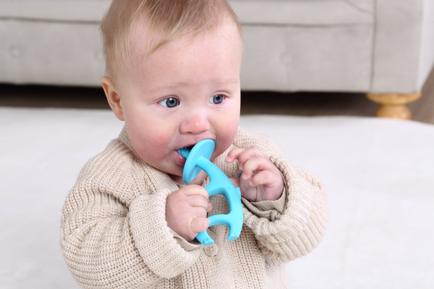 En baby holder en blå dansende elefant biterleke i silikon med ergonomisk design som tåler oppvaskmaskin