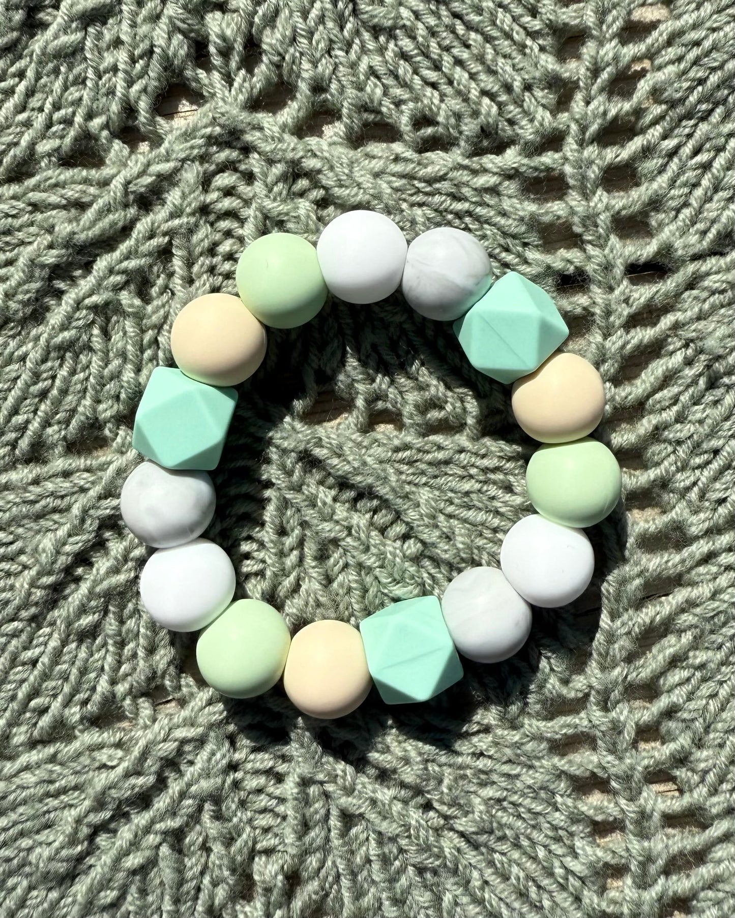 Pastellfarget håndlaget bitering i bpa fri silikon med runde og geometriske perler som lindrer ømme gommer