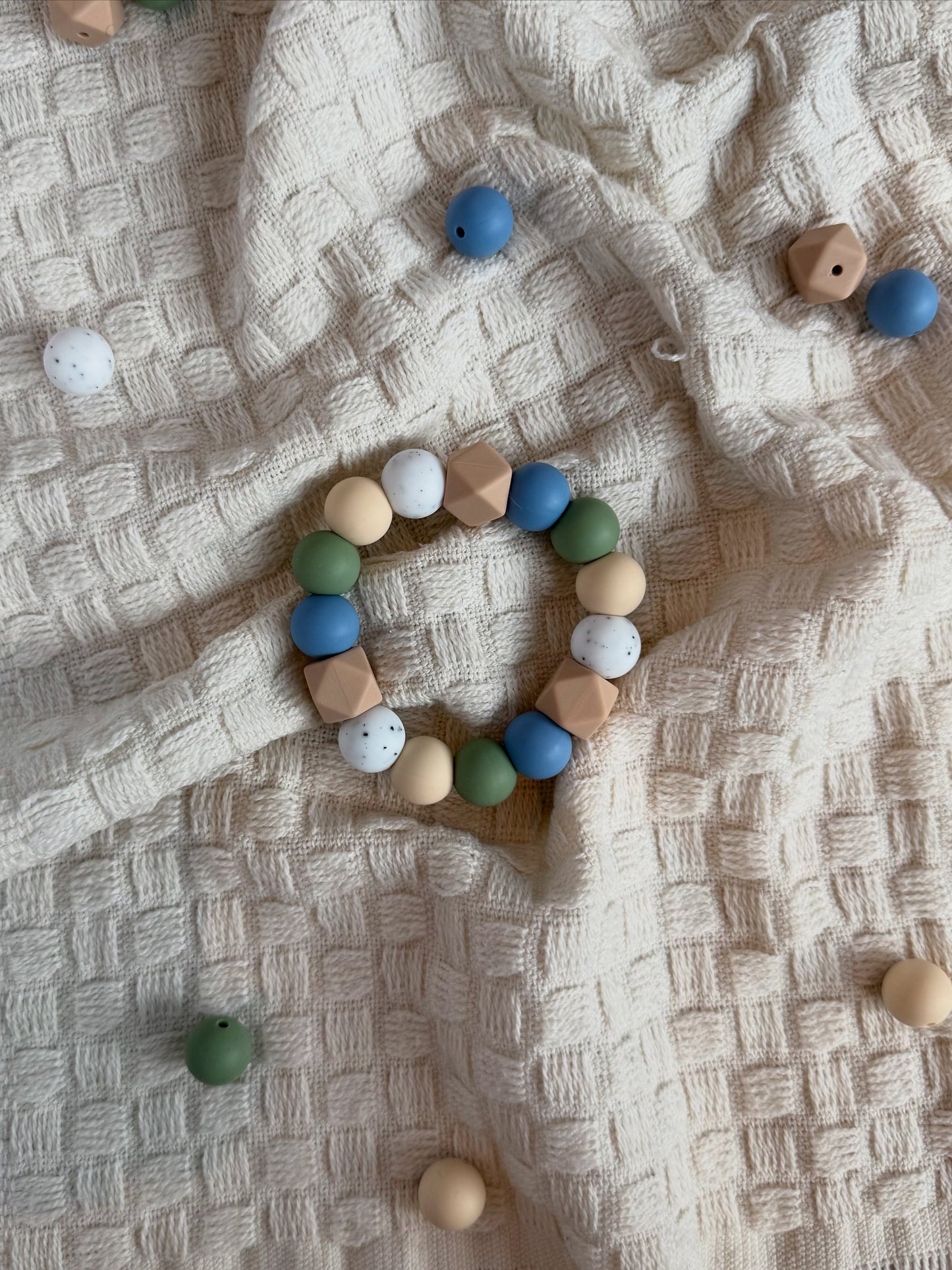 Tellus håndlaget bitering i bpa fri silikon med blå, grønn, beige og hvite perler som lindrer ømme gommer