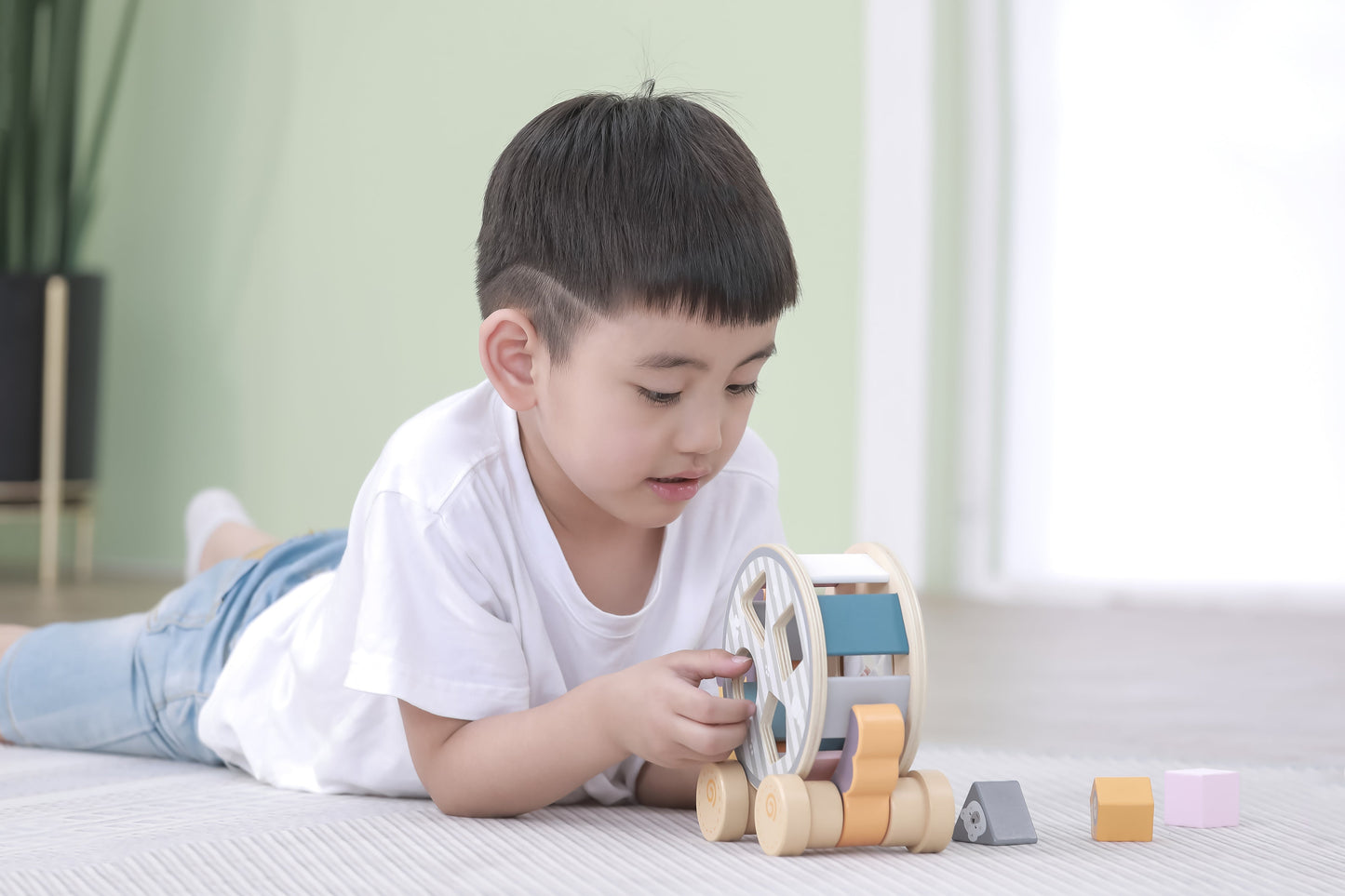Wooden draleke toy car with colorful blocks and circular wheels in draleke med putteeske pinnsvin design