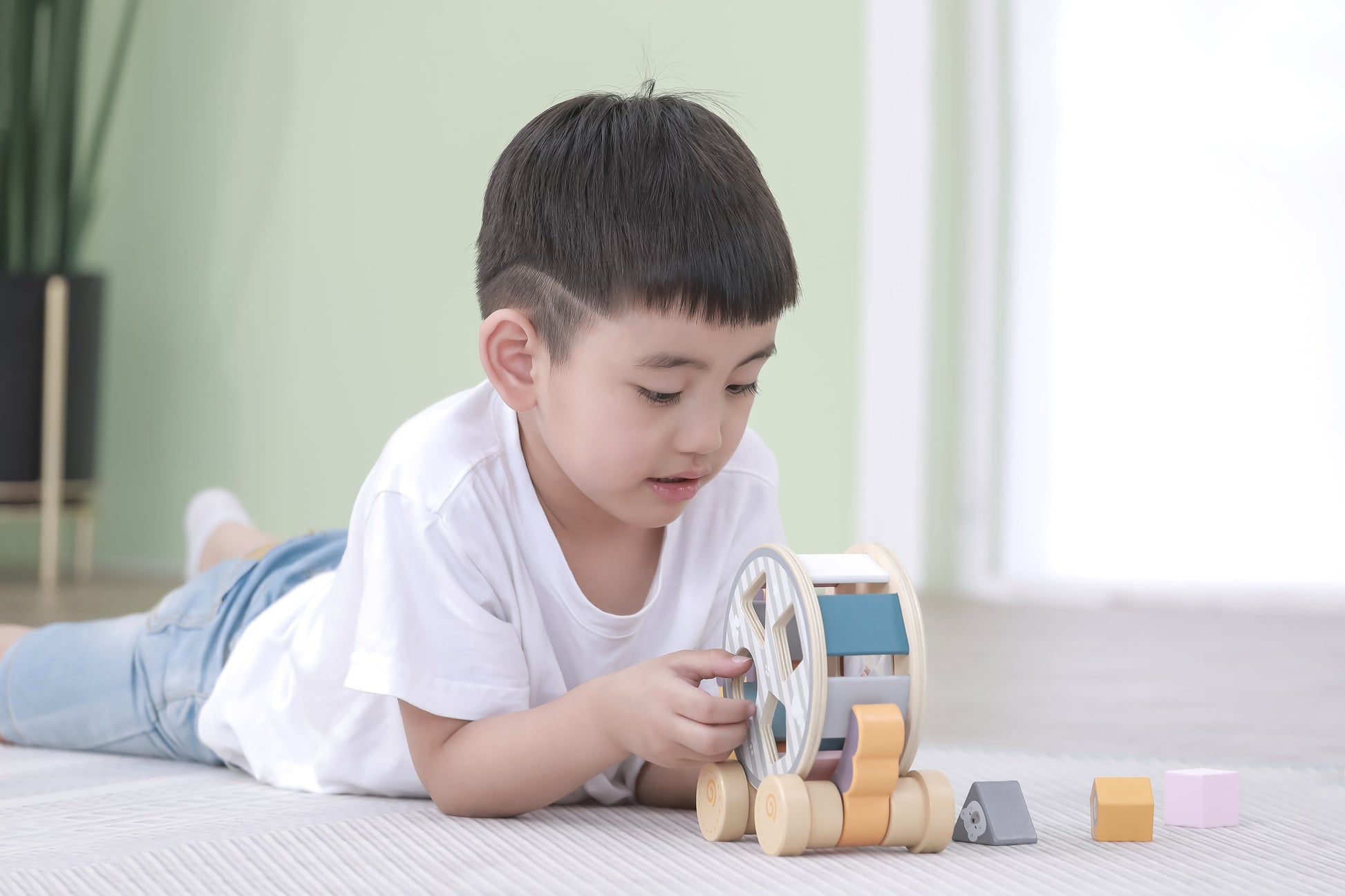 Wooden draleke toy car with colorful blocks and circular wheels in draleke med putteeske pinnsvin design