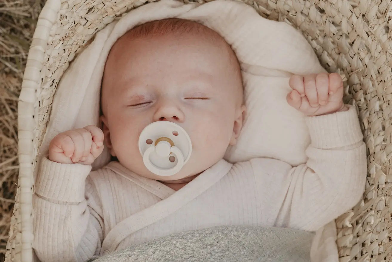 En myk hvit pacifier med rund, glatt design og subtile gullfargede detaljer i babyens munn for multifunksjonell babyklut musselinkluter 70x70 2pk ivory