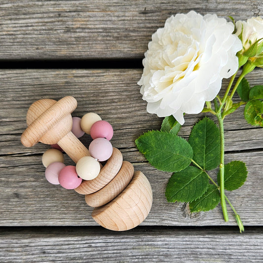 En fsc sertifisert treleke trerangle rosa med ubehandlet bøketre og pastellrosa og kremfargede perler