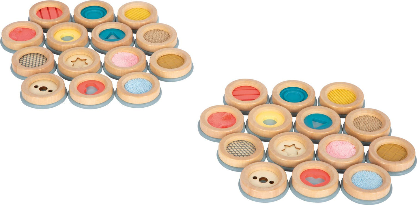 Set of wooden sensorisk memo discs with assorted pastel and vibrant colors and textured inserts in medfølgende bomullsposen